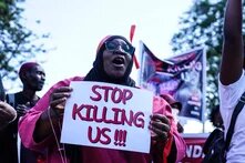 Protest against femicide in Nakuru, Kenya - 27 Jan 2024 A protester marches while holding a placard during the demonstration. 